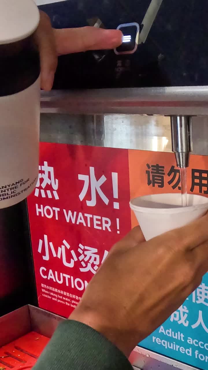 공항에서 뜨거운 물 분배기를 사용하는 사람