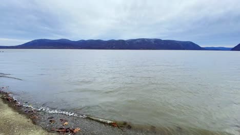 Walking-hyper-lapse-time-lapse-of-a-secluded-beach-during-winter-with-mountains-in-the-background