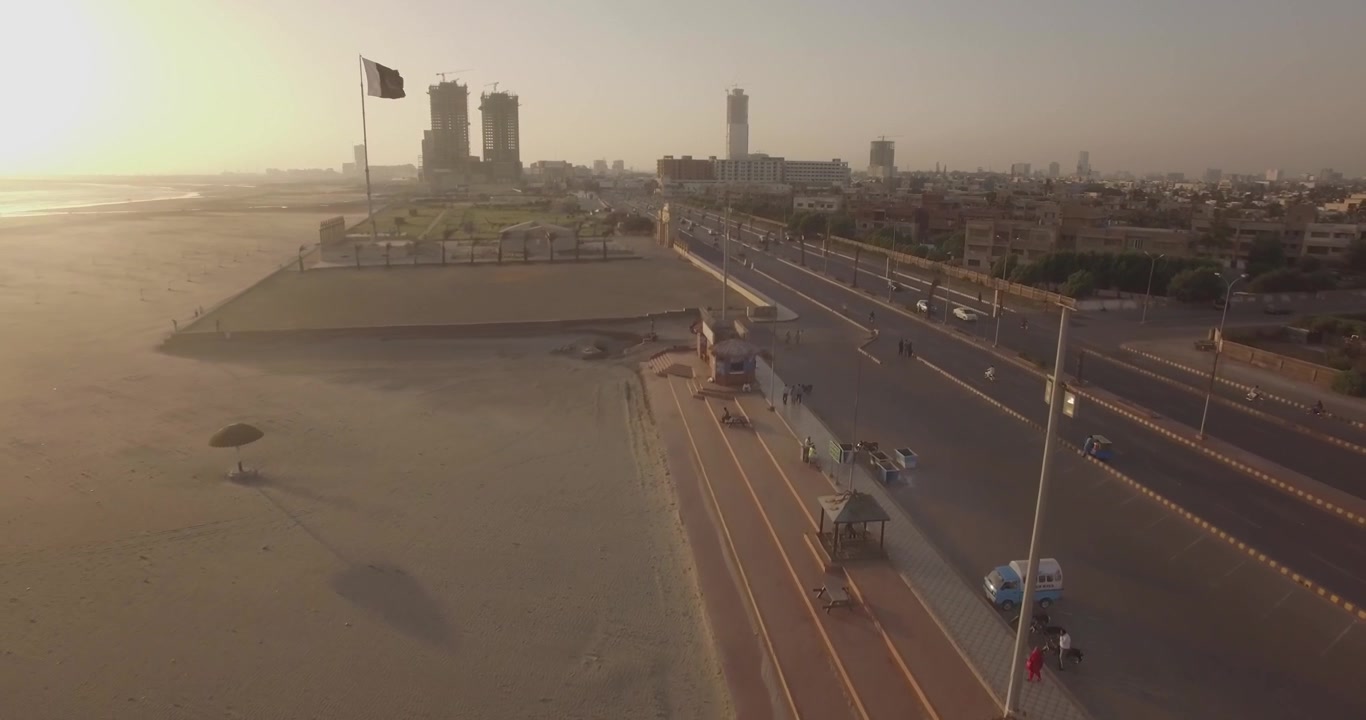 Clifton Beach Karachi, Pakistan, con bandiera pakistana in vista. Ripresa serale con drone sulla spiaggia, in volo in avanti