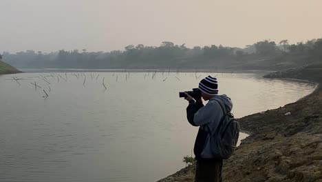 profile medium close up of man taking photographers of polluted river in sylhet