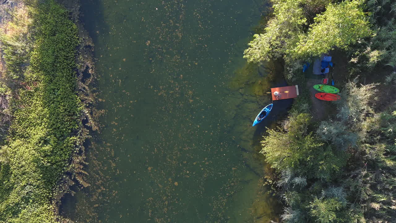 Un kayaker che sale sulla sua barca per una pagaiata e scende lungo il fiume Russian in California - vista aerea dall'alto