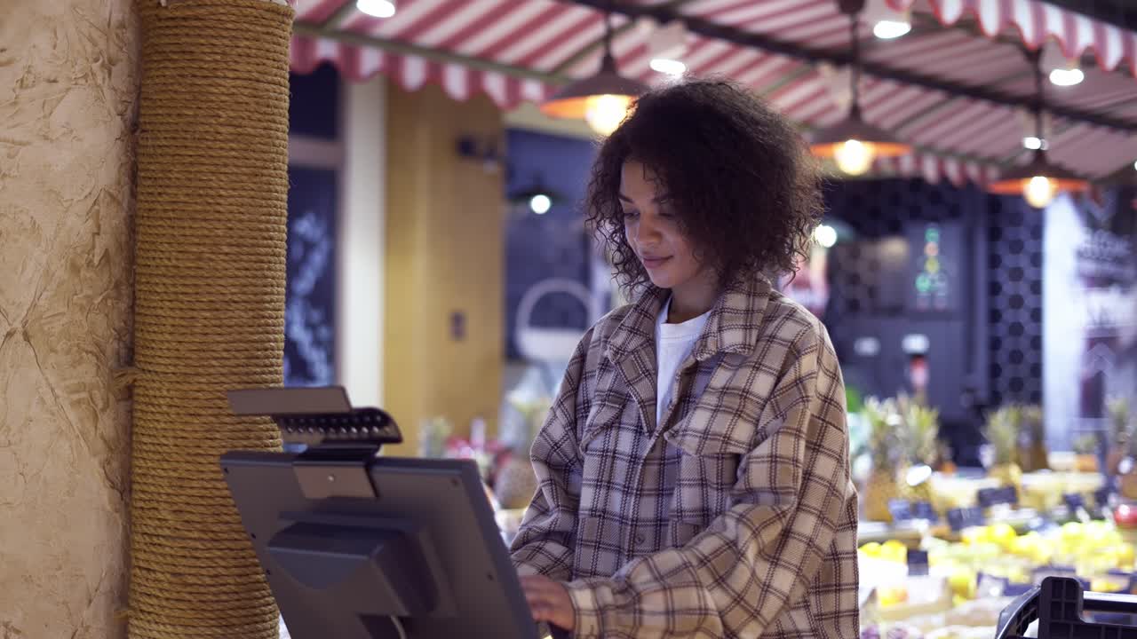 Mujer pesando plátanos, alimentos ecológicos, en una frutería o supermercado.