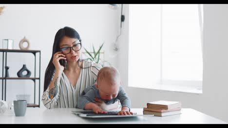 madre trabajando con el bebé en casa