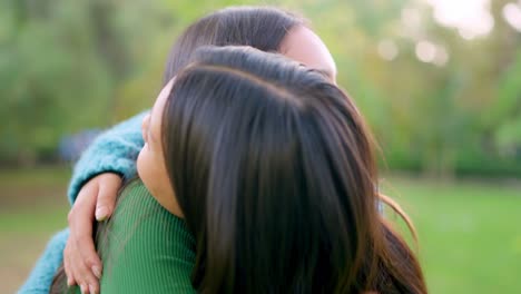young asian women sharing a happy hug in a park