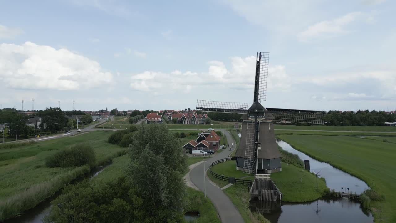Beautiful aerial shot of a historic Dutch windmill in Volendam with fields and village in the background