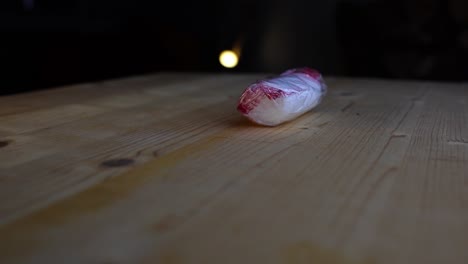 venda de gasa individual envuelta en plástico sobre una mesa de madera sobre un fondo oscuro