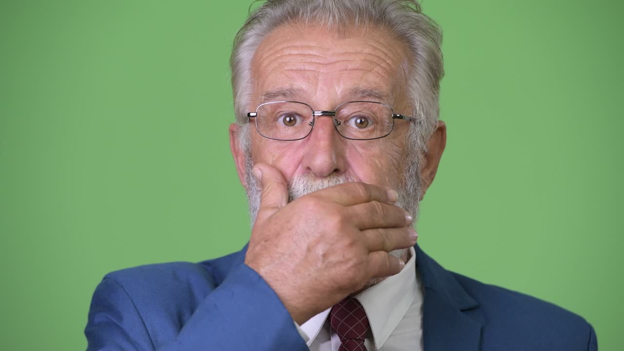 hombre de negocios barbudo y guapo contra un fondo verde.