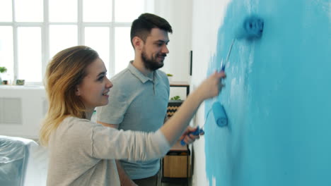 couple painting a wall blue