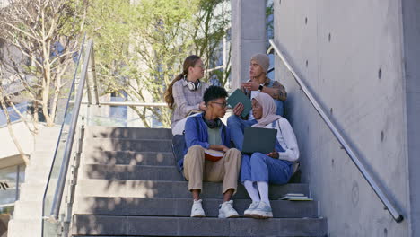 group of students studying together on campus stairs