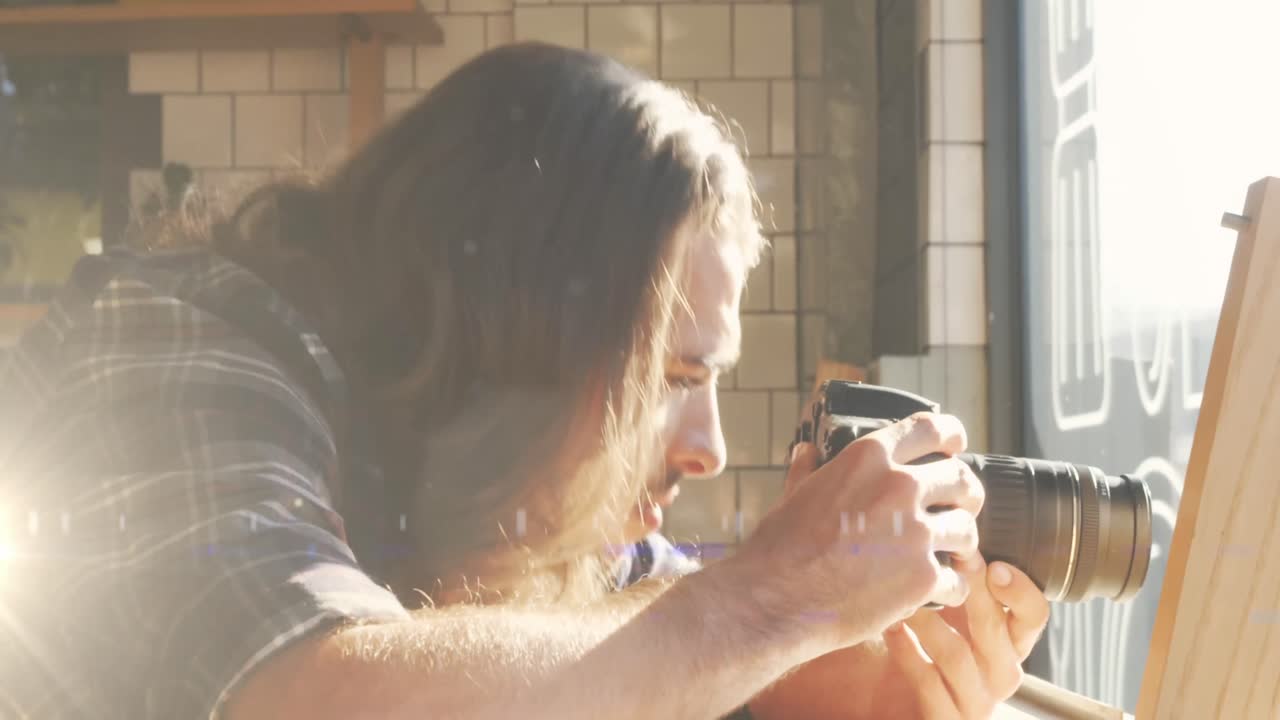 디지털 카메라로 사진을 찍는 백인 남성 사진작가에 대한 빛의 반점