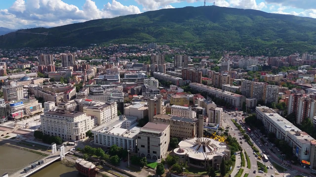Veduta aerea con drone del centro di Skopje con il fiume Vardar, ponti moderni e panorama di edifici. Viaggio nel paesaggio urbano della capitale della Macedonia del Nord