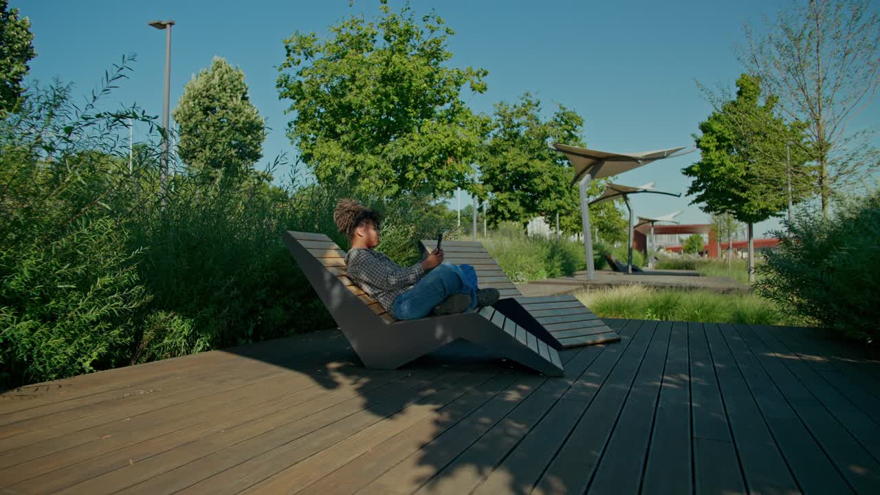 Kvinde slapper af i en park på en liggestol