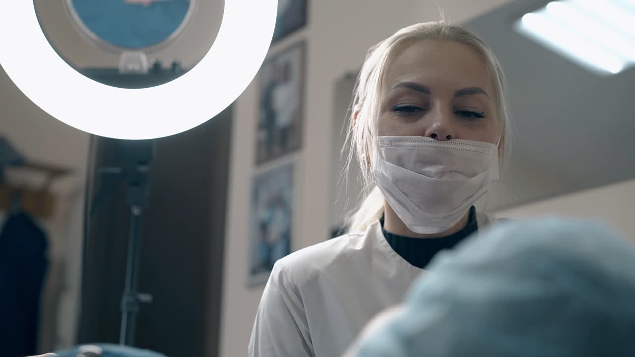 여성이 미용실에서 이마 문신에 대한 고객의 질문에 대답합니다.