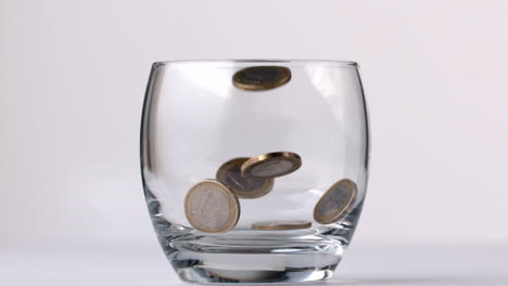 euro coins falling in a glass