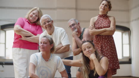 Group-of-senior-dancers-with-teacher-posing-for-camera-in-studio