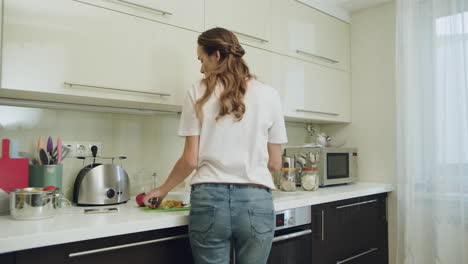 Young-woman-having-fun-dancing-alone.-Female-cooking-dinner-at-kitchen-at-home