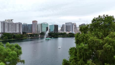 Abriéndose-Paso-Entre-Los-árboles-Para-Revelar-El-Lago-Eola-En-Orlando,-Florida