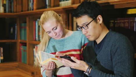 amigos de estudiantes juntos miran el libro en la biblioteca 1