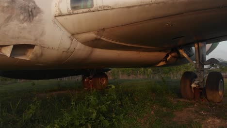 Flying-underneath-a-abandoned-airplane-at-Bali-indonesia,-aerial