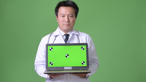 성숙한 일본인 남성, 초록색 배경의 의사