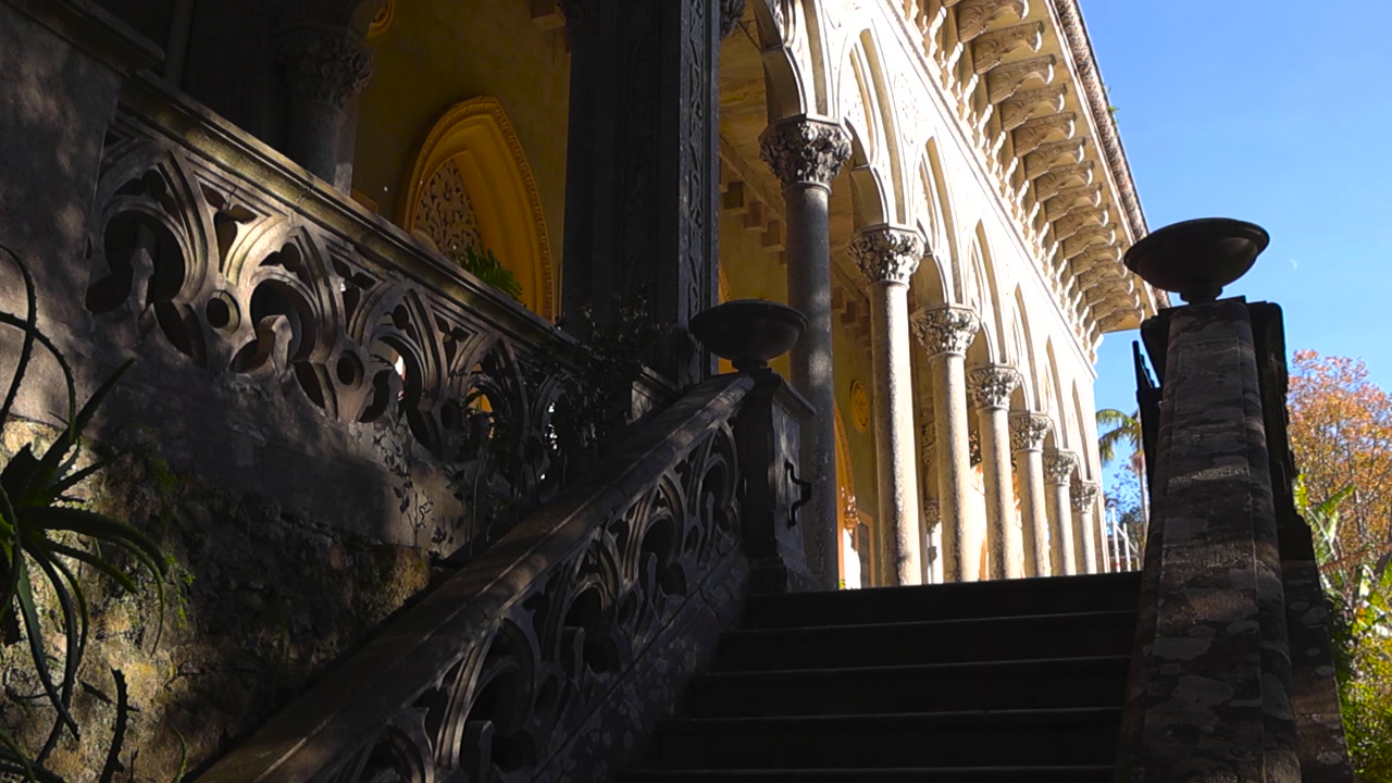 View of Monserrate Palace as if slow ascend steps to staircase leading to ornate arched gallery with Gothic columns and Moorish architecture in Sintra Portugal. Balcony with oriental arches corridor