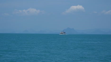 handheld view out on ship on open ocean with mountain silhouettes in distance