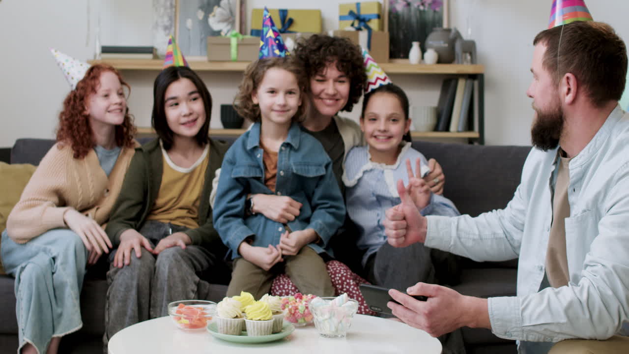가족과 손님들이 집에서 포즈를 취하고 있습니다.