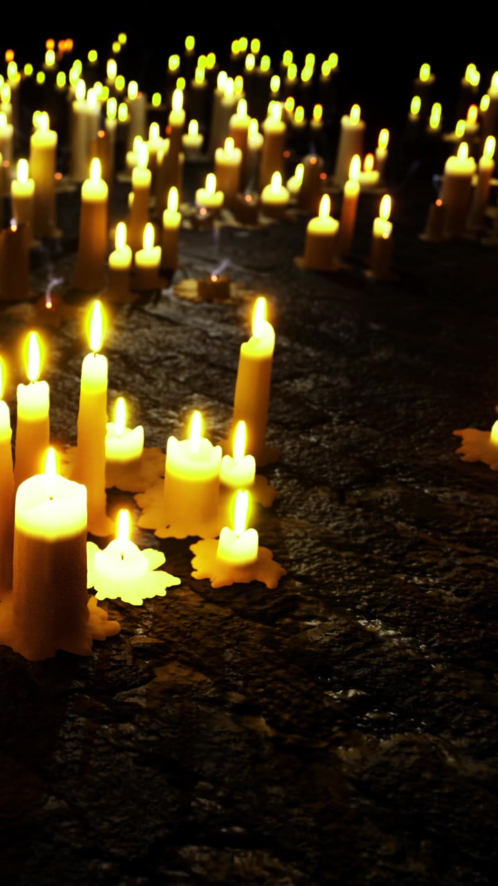 Candele accese a terra durante un raduno serale per ricordo e riflessione.