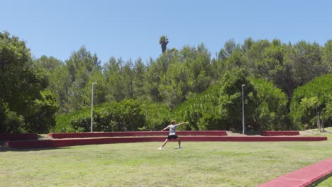 a person doing a warrior ii yoga pose in a grass field