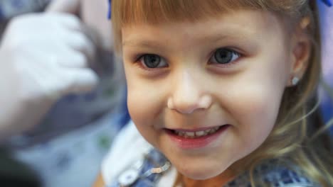 girl shows tongue to doctor. reception of the patient in dentistry. doctor's hands in white rubber gloves