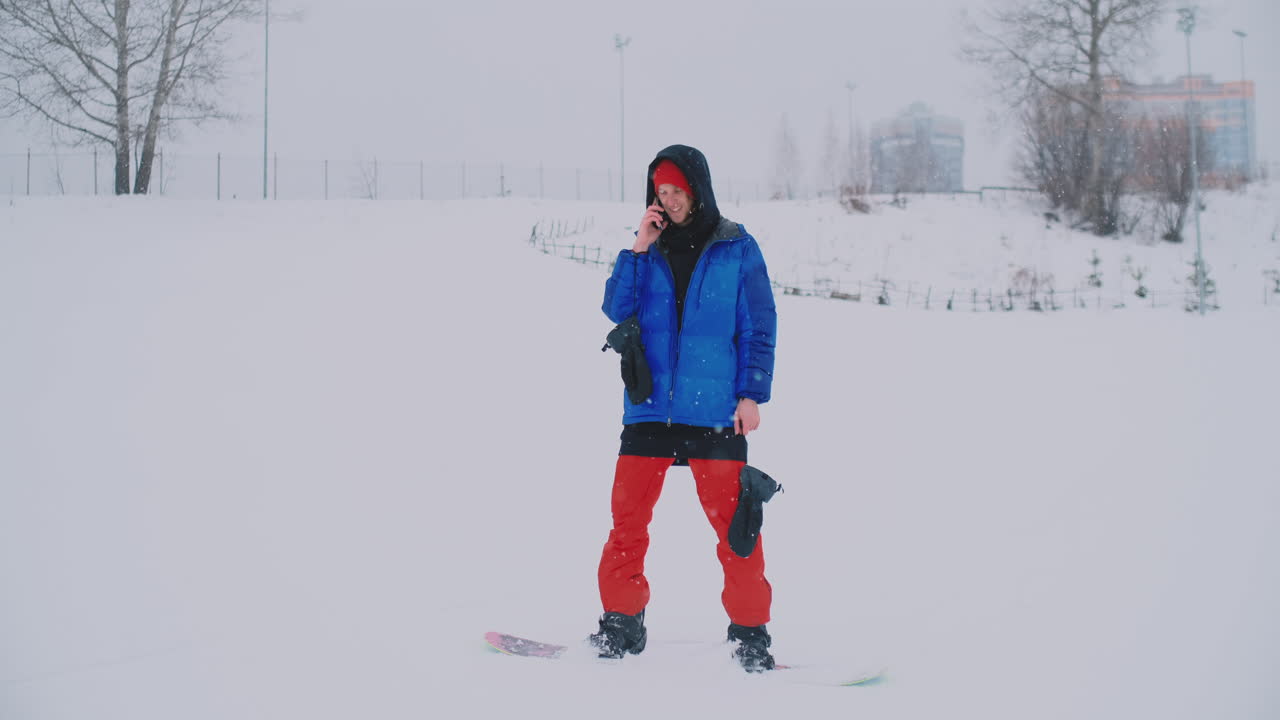 мужской сноубордист в синей куртке транслируется в прямом эфире с вашего смартфона на горнолыжном курорте