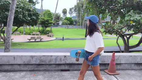 woman walking in a park with a skateboard