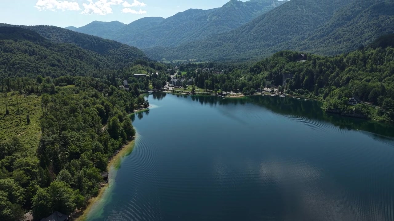 Ripresa con drone del villaggio costiero del Lago di Bohinj e delle calme acque alpine, Slovenia.