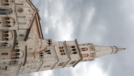 disparo estático vertical de la catedral de módena contra el cielo nublado, italia