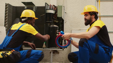 workers servicing air conditioner