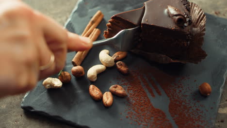 mano humana de primer plano cortando pastel de chocolate en cámara lenta.