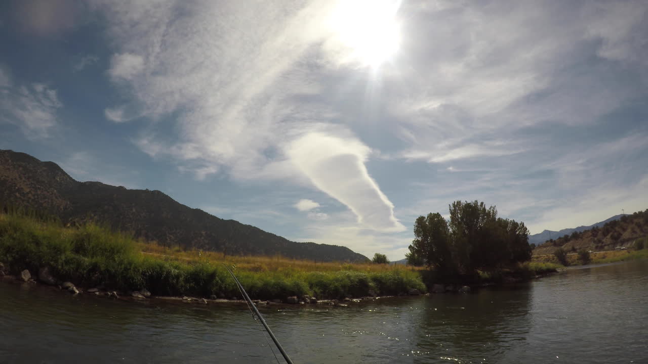 casting a fly rod on a river in the mountains