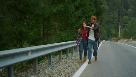 backpackers trekking mountains highway in mountain forest. couple hug on travel.