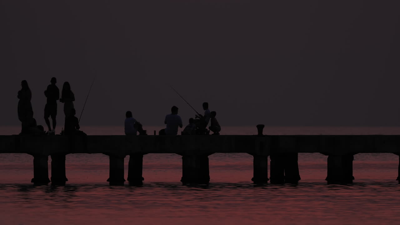 Silhouettes on a pier at Greek sunset