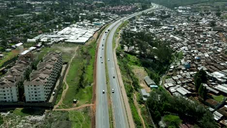 aerial flyover road with driving cars surrounded by poor urban slums in nairobi during sunny day