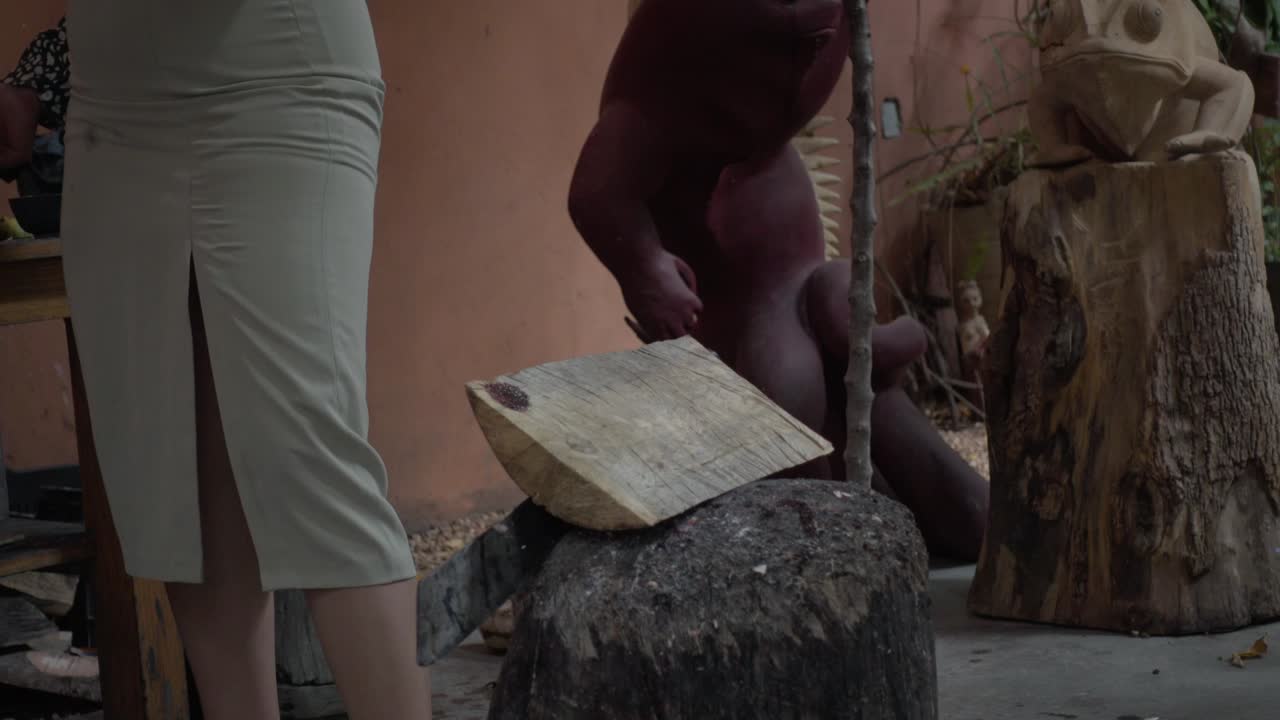 나무 조각 전문가 여성이 오아카카의 장인 작업장에서 알레브리제 제작 과정을 설명합니다.