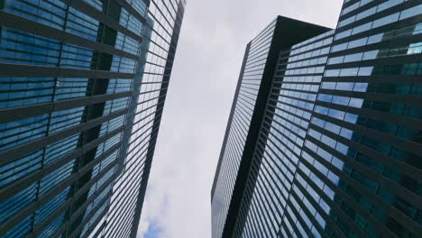 Low-angle-rotating-shot-of-skyscrapers-of-the-business-district-in-a-modern-city,-banking,-finance,-and-development-concept