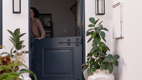 High-five-and-mother-welcome-son-walking-in-a-home