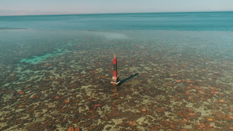 aerial shot for the red sea of egypt in the north beside hurghada with the drone moving forward towards a light house on a coral island of abu nuhas coral island