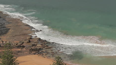 Wellen,-Die-Auf-Felsigem-Strand,-Statischem-Seitenwinkel,-Walstrand-Zusammenstoßen