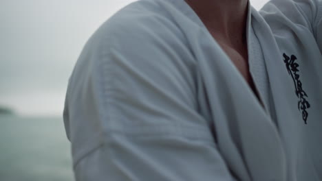 closeup man training karate near ocean. hands practicing fighting exercises.