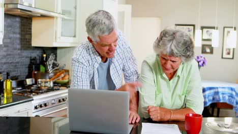 Senior-couple-discussing-bill-while-using-laptop-4k