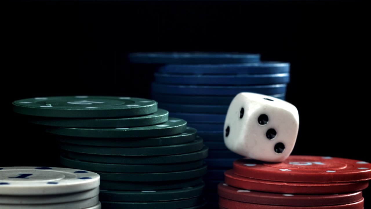 Hvide terninger falder og lander på stakke af pokerchips.