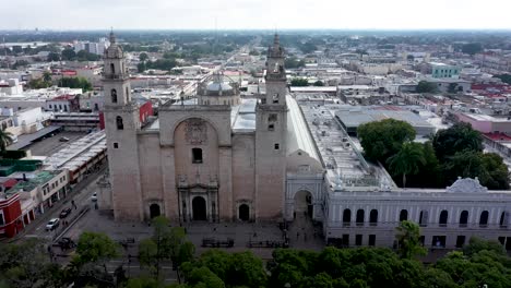 Aerial-camera-backing-slowly-away-from-the-Cathedral-of-Merida-at-the-Grand-Plaza-in-Merida,-Yucatan,-Mexico-at-sunrise