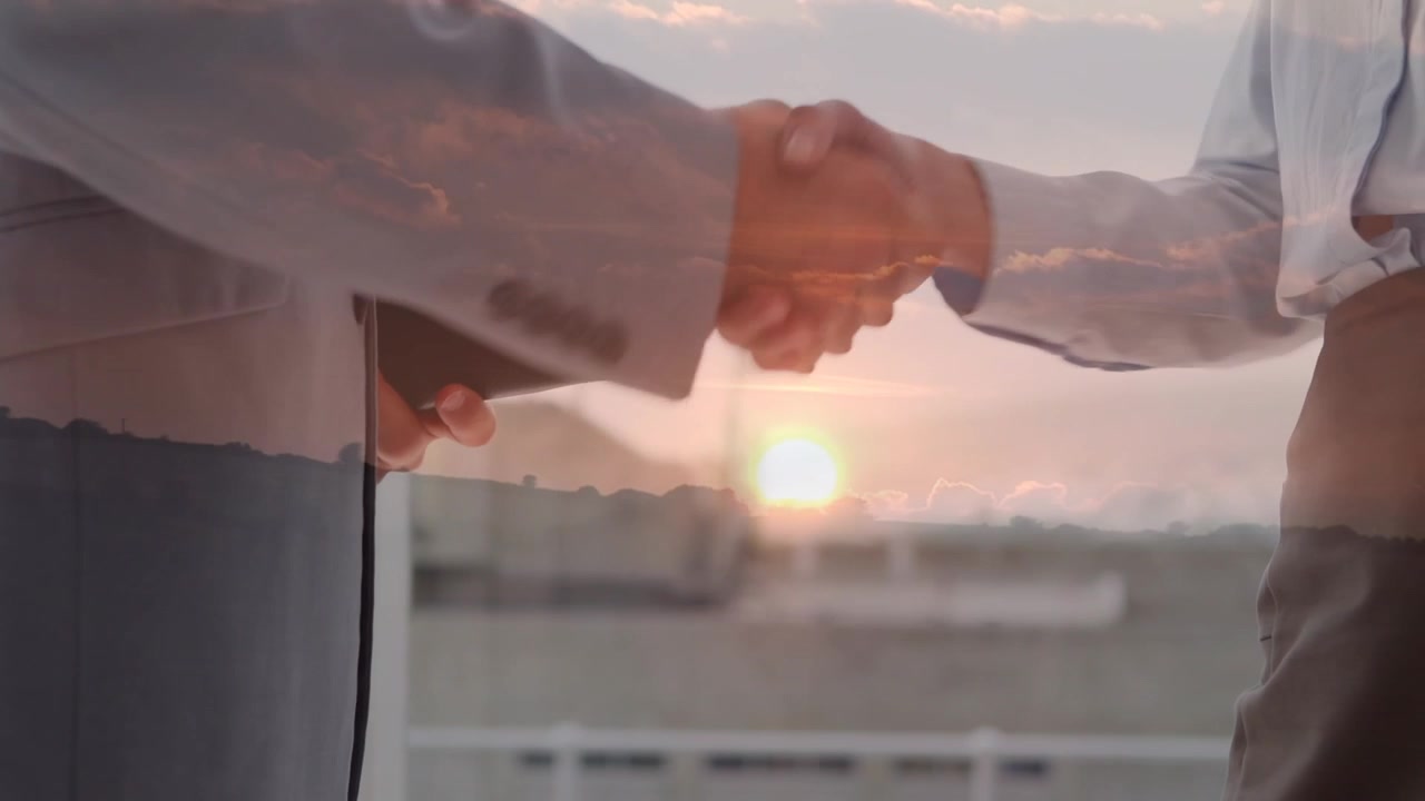 Animazione di uomini d'affari caucasici che si stringono la mano su un paesaggio al tramonto
